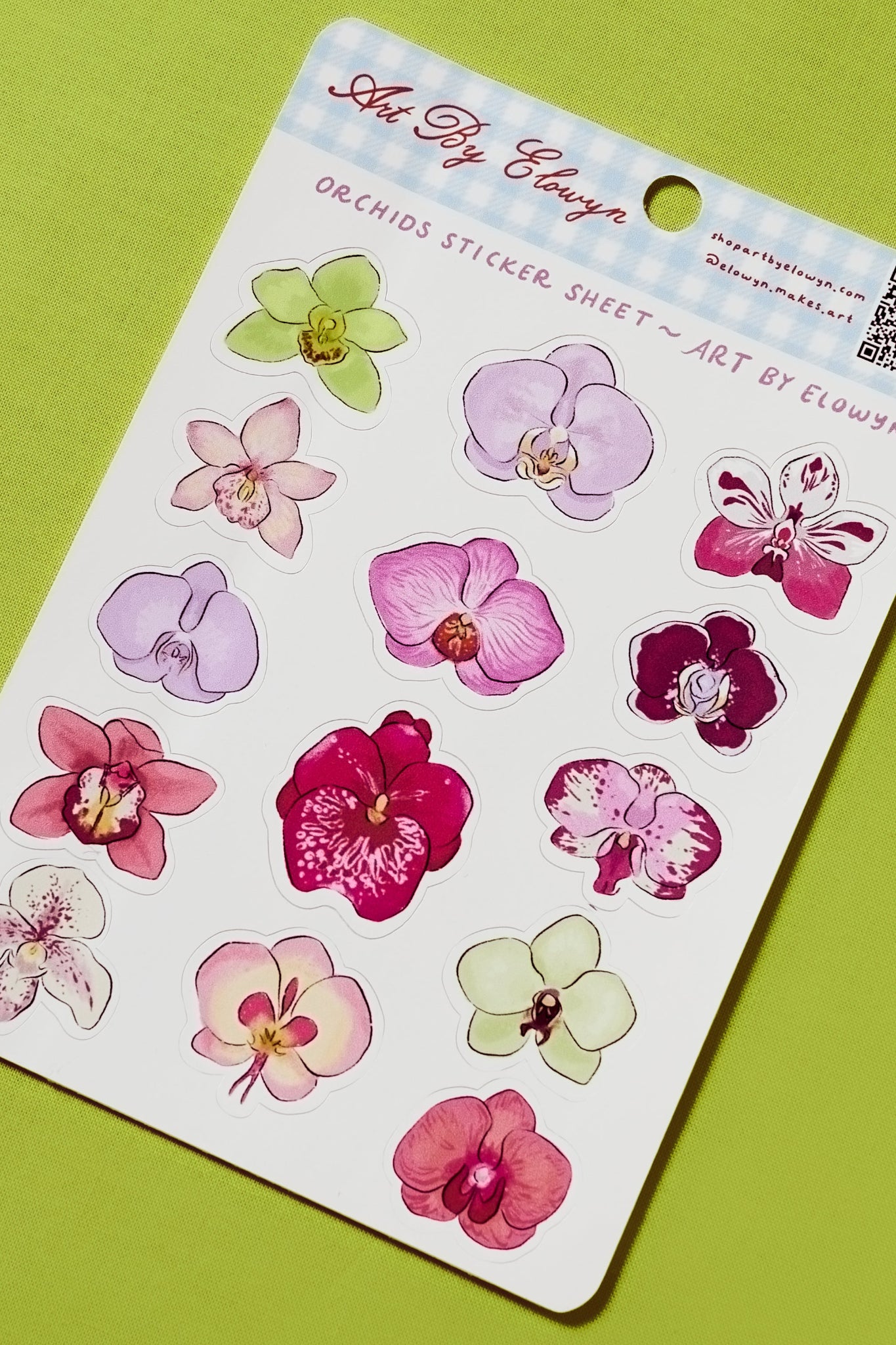 Sheet of orchid stickers with 'Art By Elowyn' branding on a green background