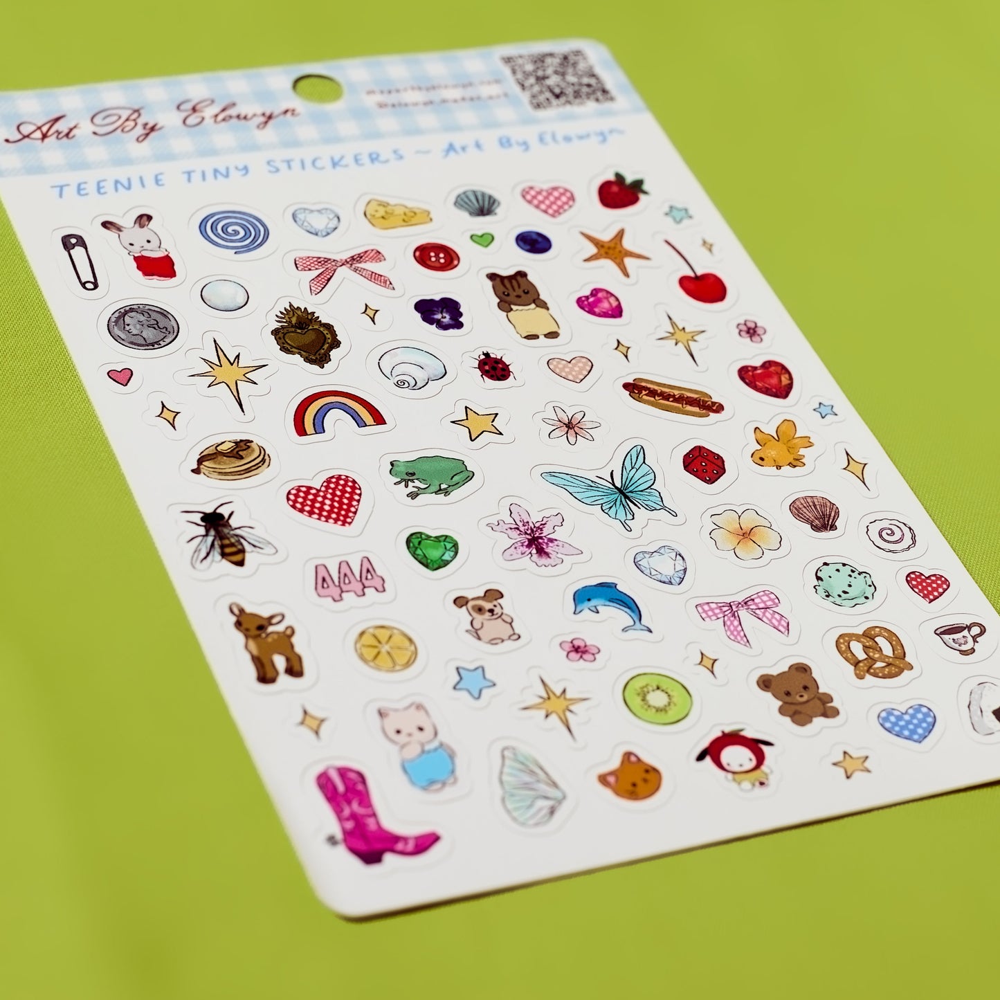 Sheet of colorful stickers with various designs on a green background