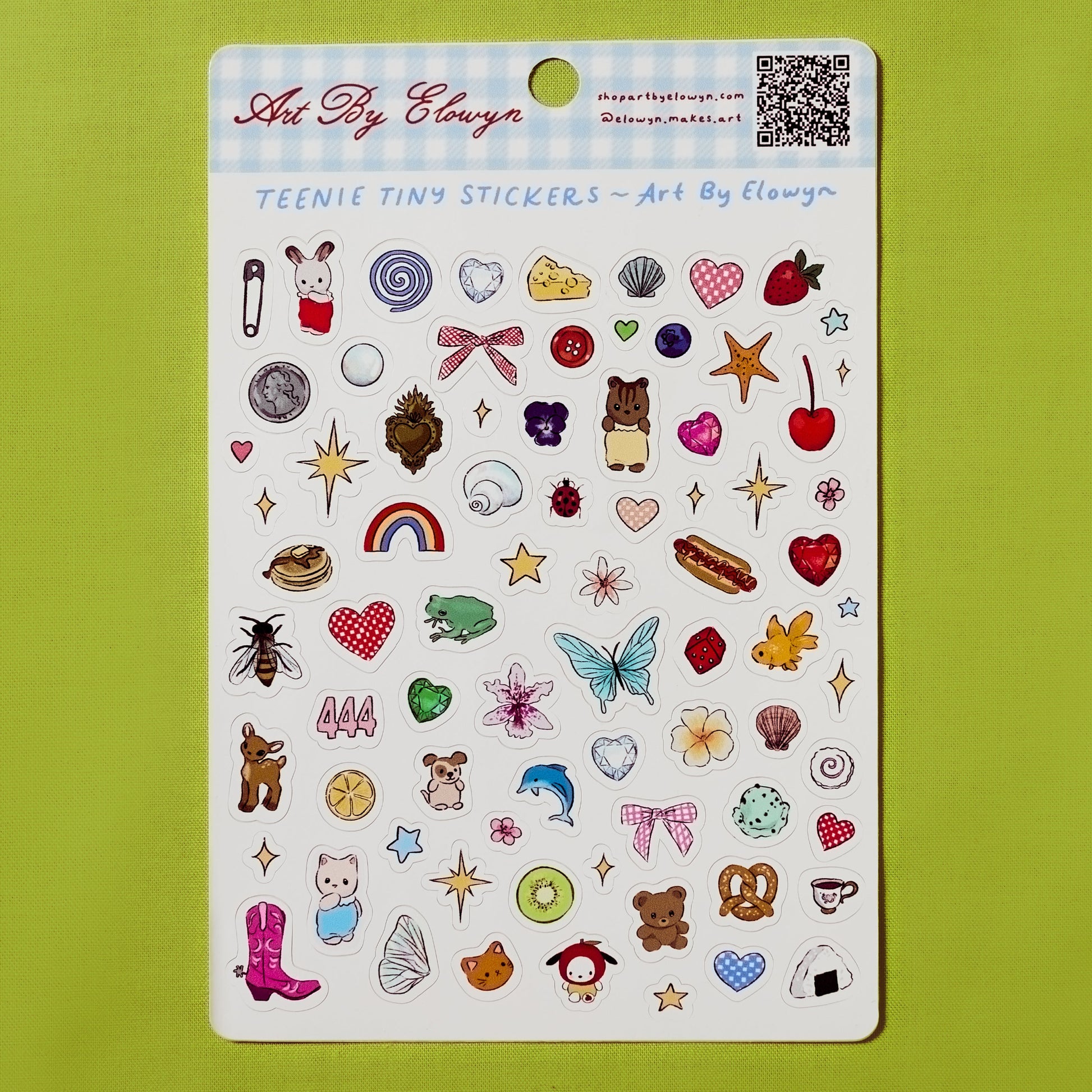 Sheet of Art By Elowyn's teenie tiny stickers with various designs on a green background