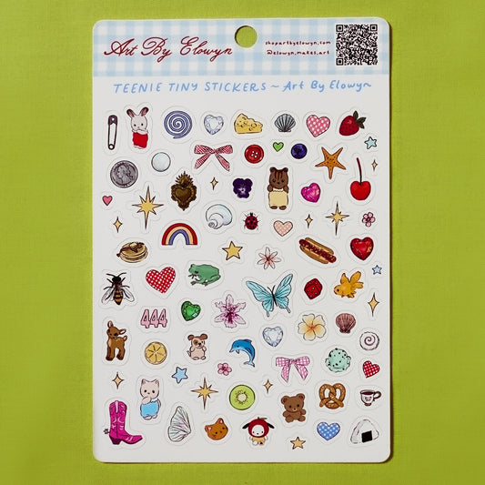 Sheet of Art By Elowyn's teenie tiny stickers with various designs on a green background